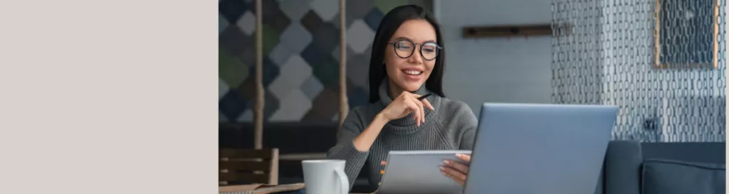 a woman smiling and looking at her computer